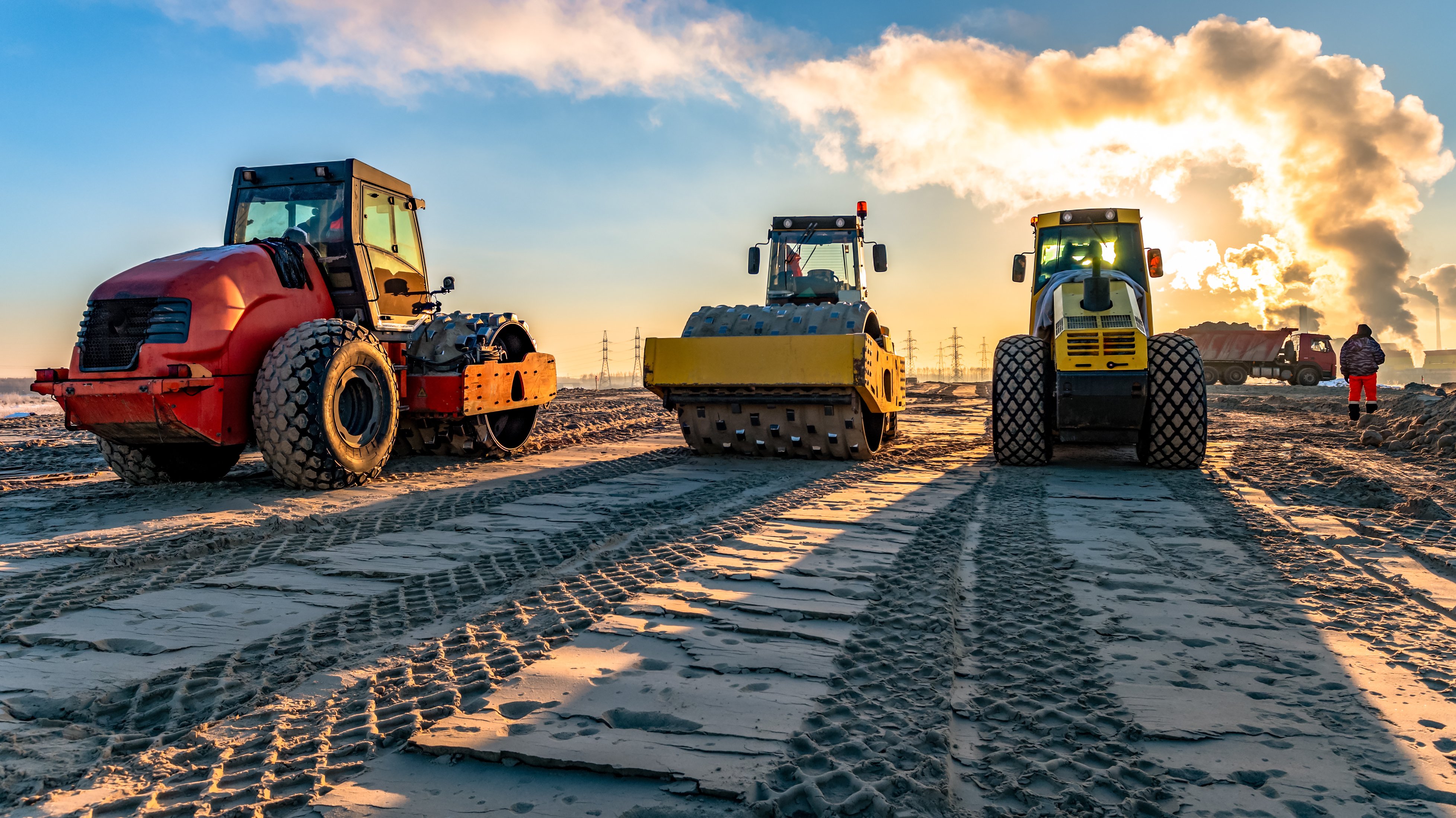 roller-compacts-soil-in-embankment-on-the-highway-construction.-sand-consolidation-on-road.-Compactor-driving-on-sandy.-wheel-marks-on-the-sand-1131321084_3912x2200