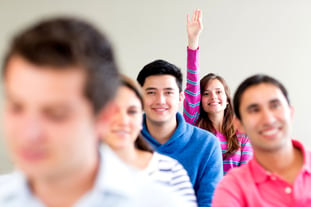 Woman in class raising her hand to participate